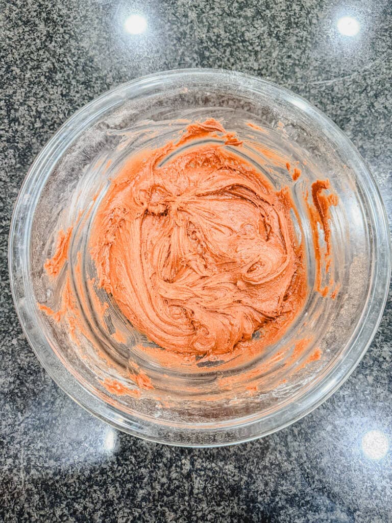 glass mixing bowl of chocolate crinkle cookie batter ready to be chilled.