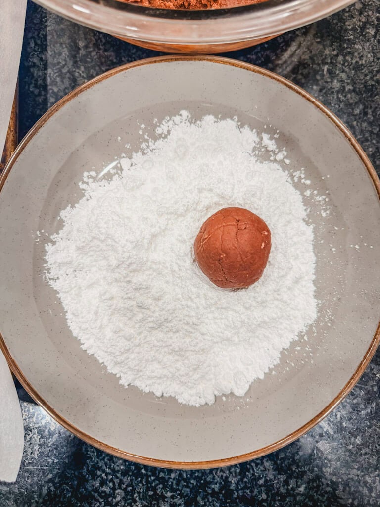 a dough ball sitting in powdered sugar.