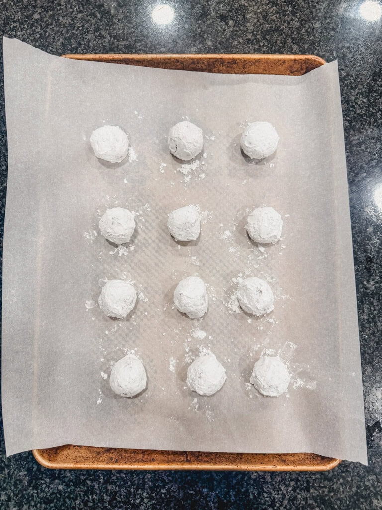 chocolate crinkle cookies rolled in powdered sugar a second time and ready to be baked.