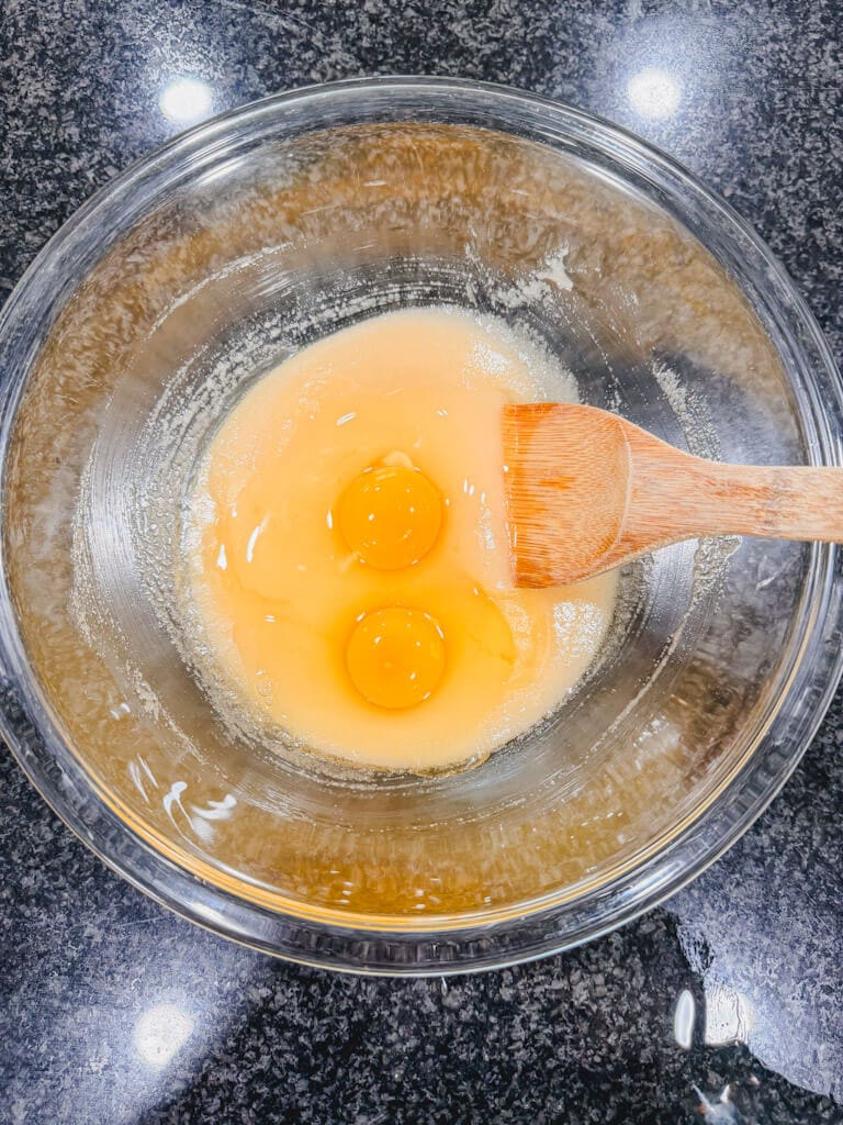 Two eggs added to the mixing bowl.