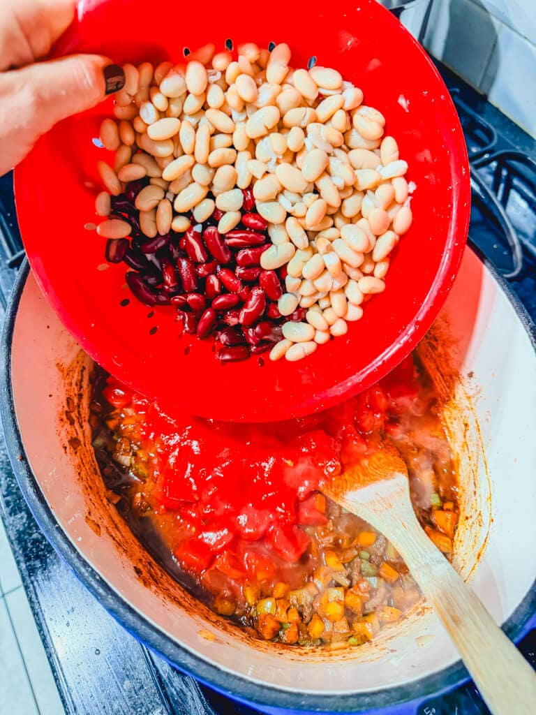 Drained and rinsed beans being held over the pot about to be added to the Chili beans.