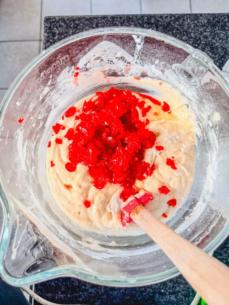 Chopped cherries added to the cake mix about to be folded into the mix.