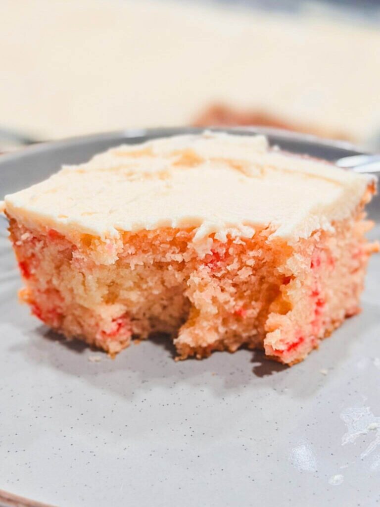 a fork-full of cherry chip cake taken out of a slice of cake.