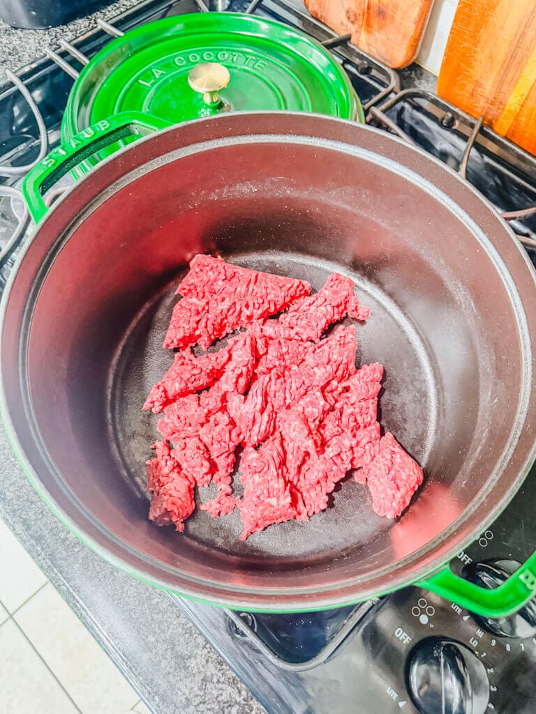 Raw ground beef in the bottom of a large pot.