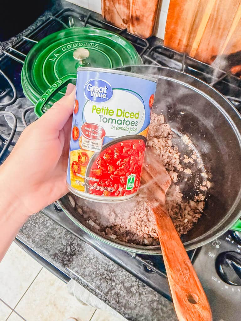 A can of petite diced tomatoes about to be added to the pot.