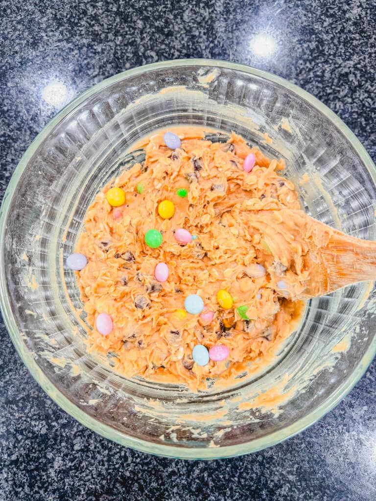 Overhead view of Monster cookies with M&M's cookie dough in a glass bowl.