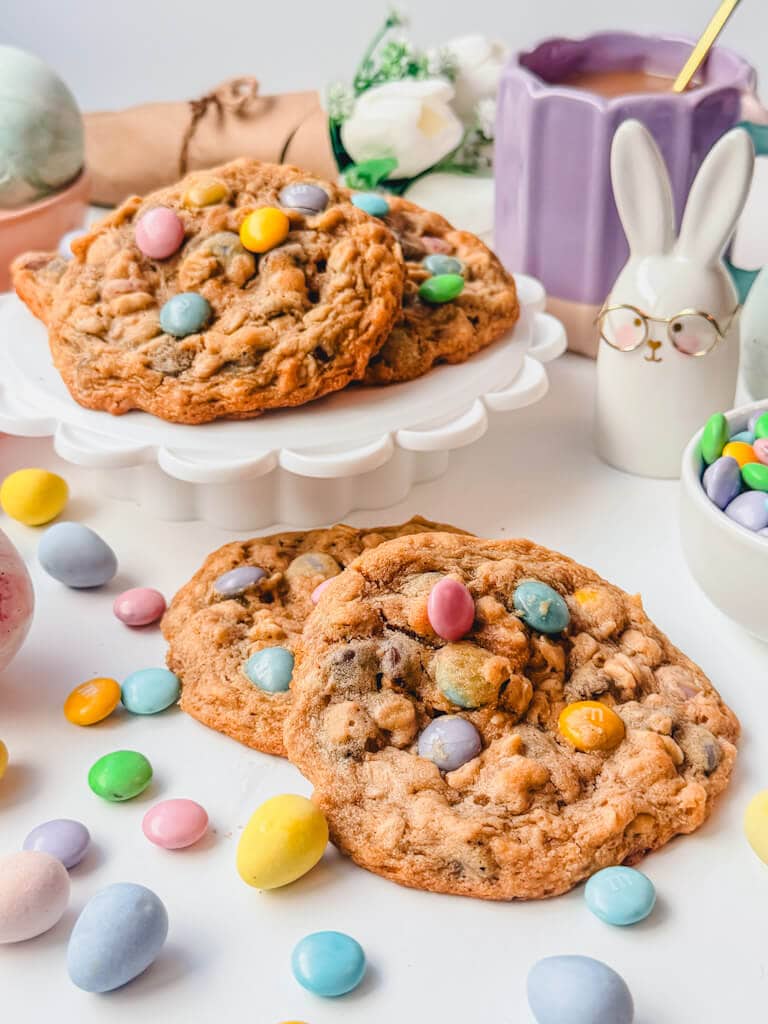 Monster Cookies with M&M's displayed on a small tray with colorful candies surrounding the cookies.
