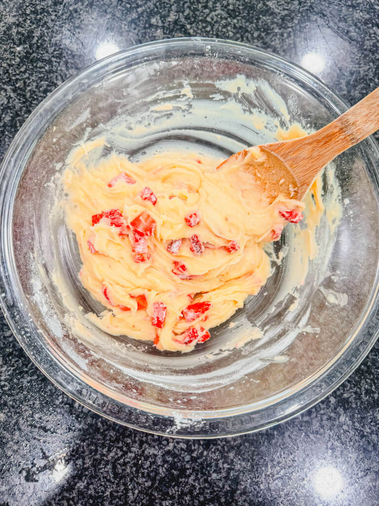 Floured strawberries added to the strawberry lemon bar batter.