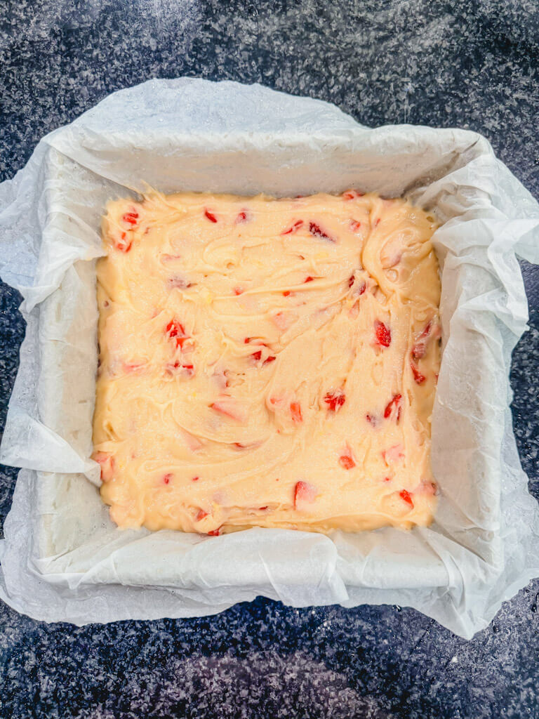 Strawberry lemon bar batter spread evenly into the prepared baking pan.