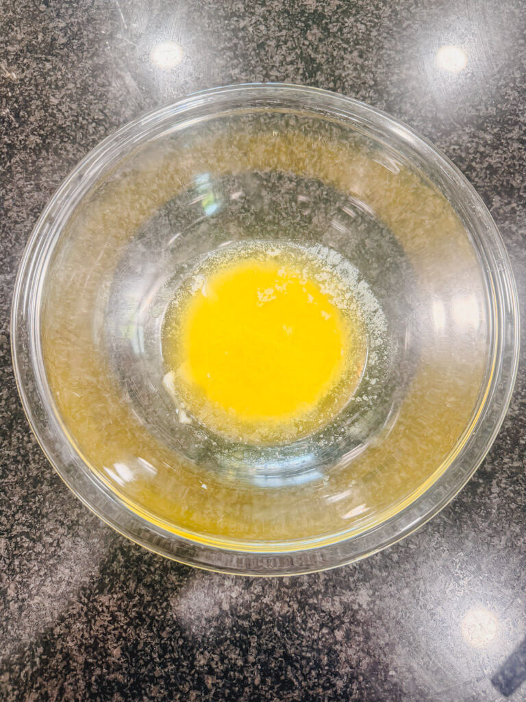 Melted butter in a glass mixing bowl.