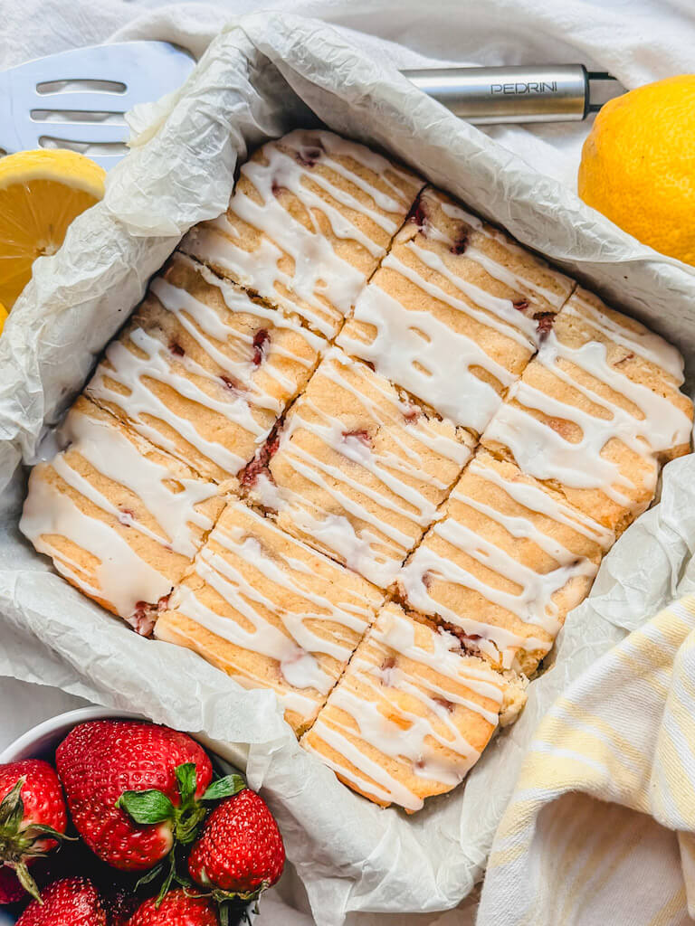 overhead view of strawberry lemon bars in the baking dish that have been cut into 9 squares.