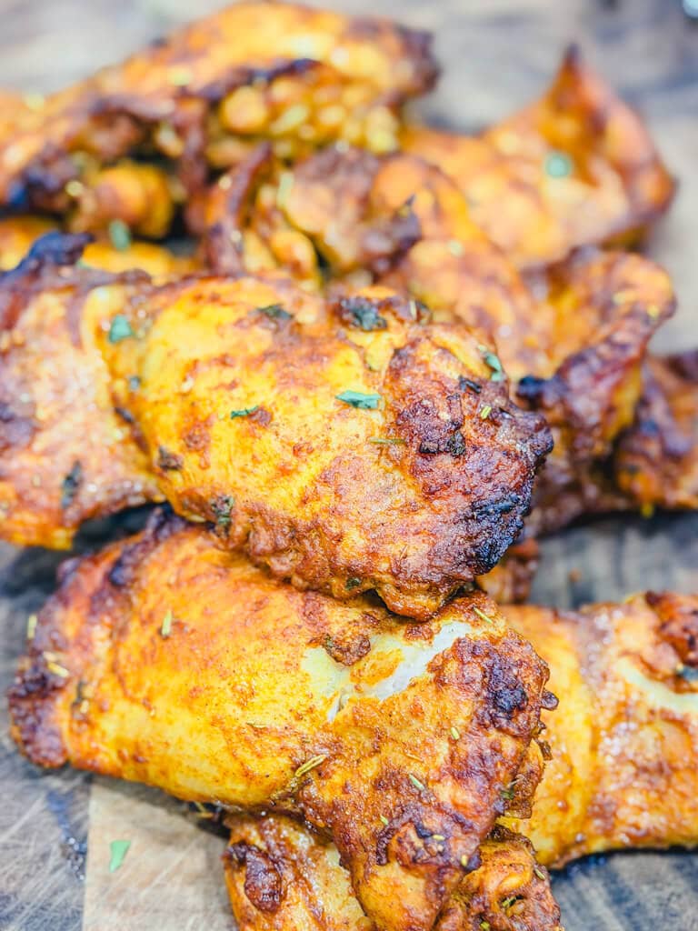 Chicken thighs resting on a wooden cutting board.