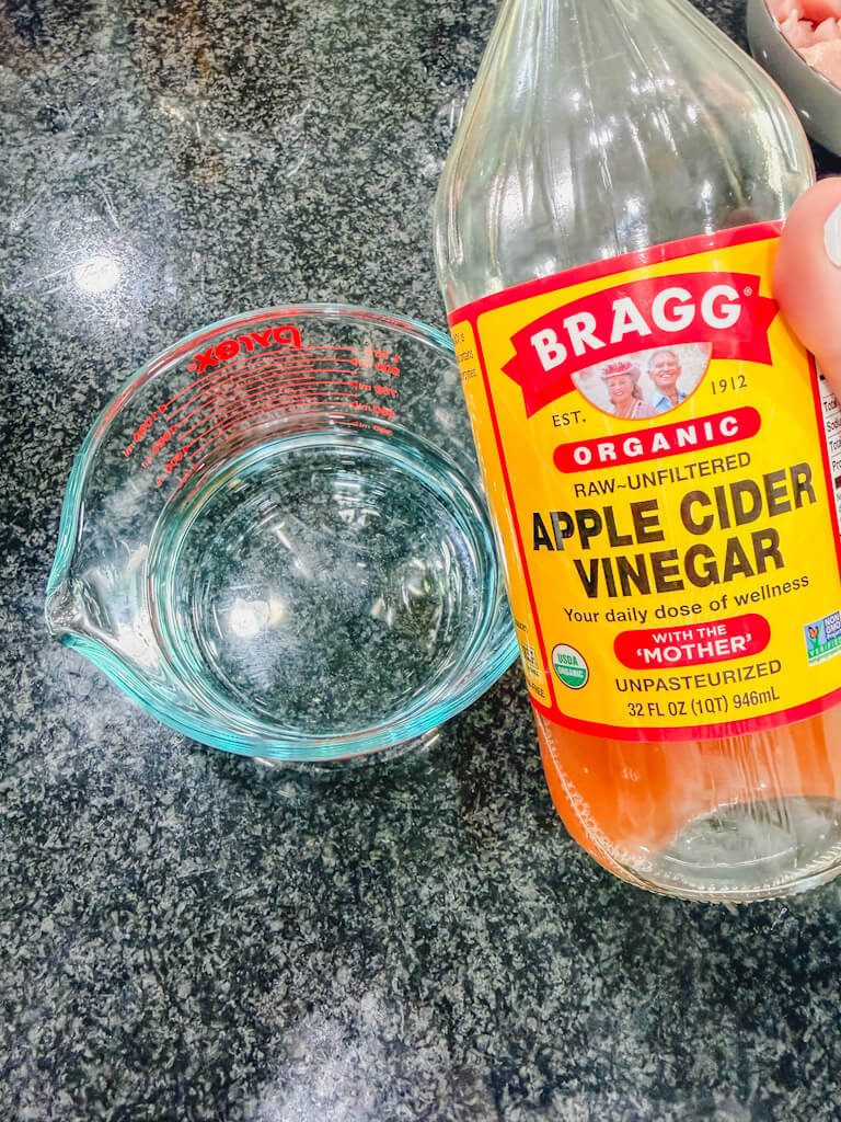 Apple cider vinegar being added to measuring cup for homemade teriyaki sauce