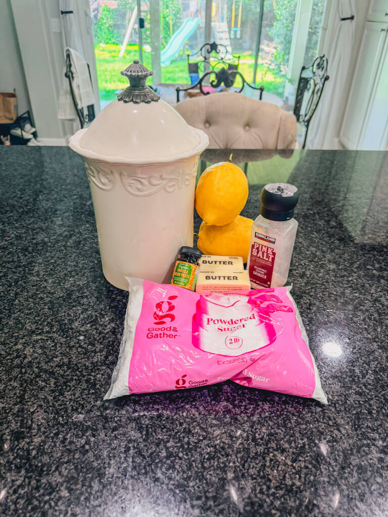 ingredients for Lemon Vanilla Bean Shortbread Cookies laid out on a black counter top.