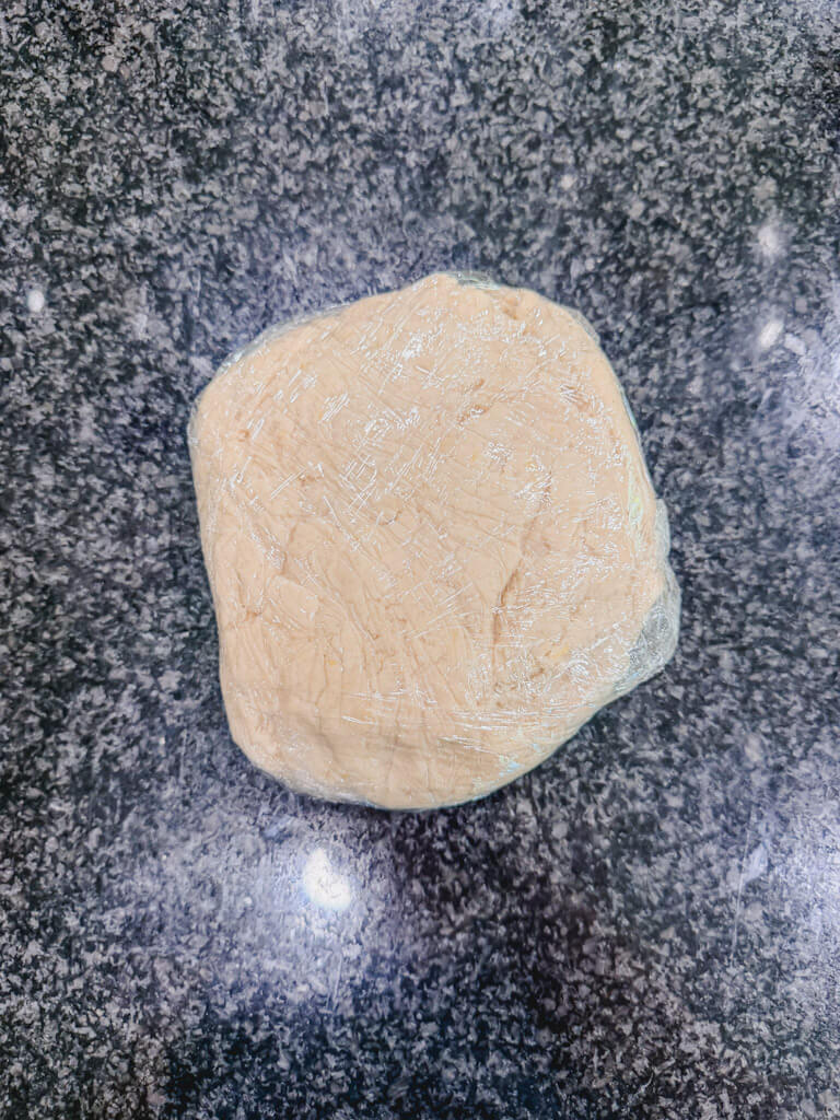 Cookie dough wrapped in plastic wrap about to go into the fridge to chill for 45 minutes.