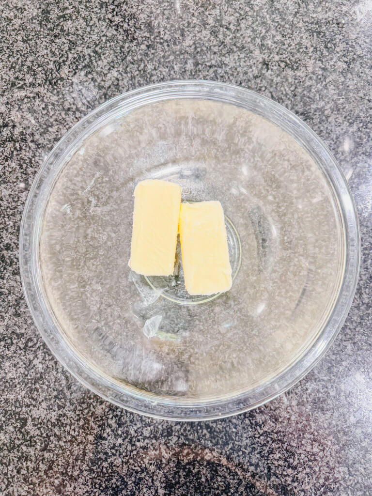 Two sticks of butter in a large mixing bowl.