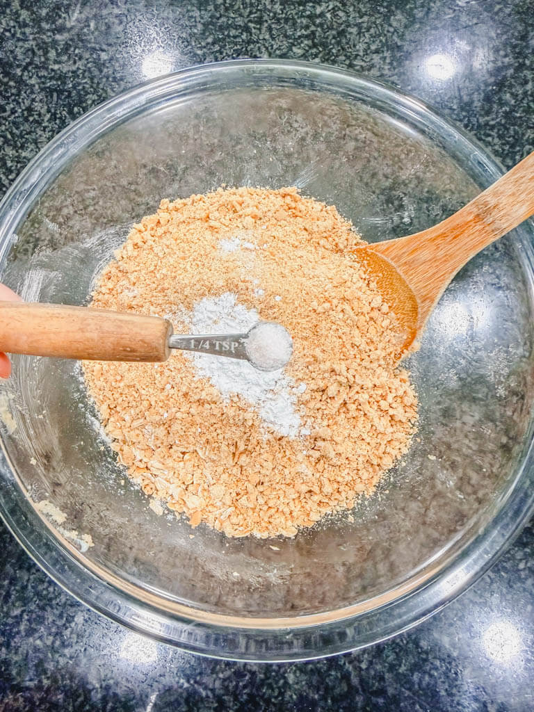 Salt being added to the mixture in a glass mixing bowl.