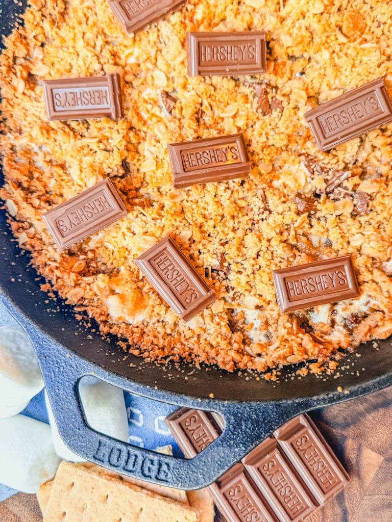 Cast Iron Skillet S'mores Pie topped with chocolate pieces and baked in a cast iron skillet.