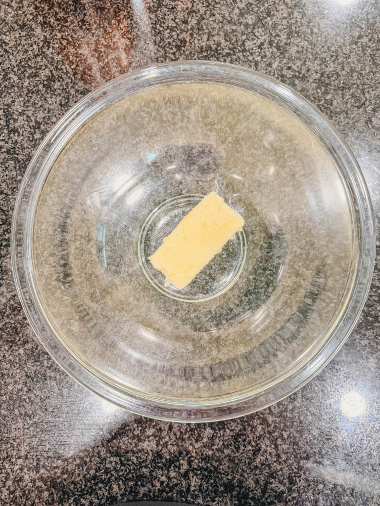 Softened butter placed in a large glass mixing bowl for Cast Iron Skillet S'mores Pie.