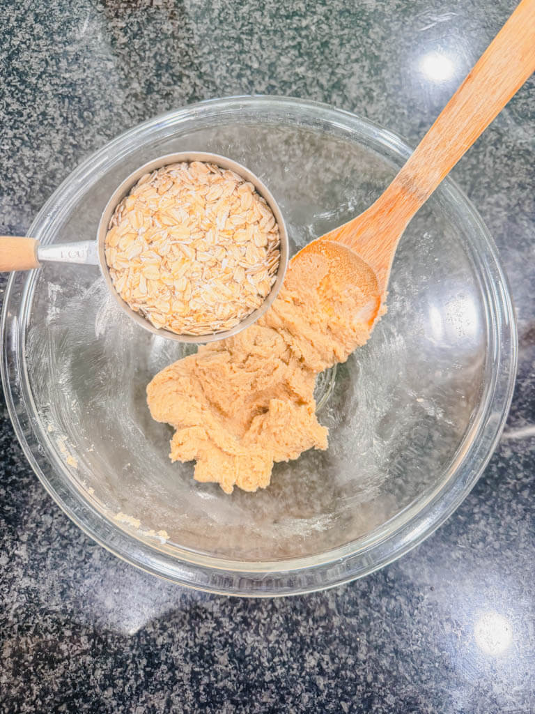 Old-fashioned oats being added to the butter and brown sugar mixture for Cast Iron Skillet S'mores Pie.