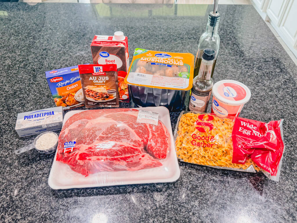 slow cooker beef stroganoff ingredients on a black counter top.