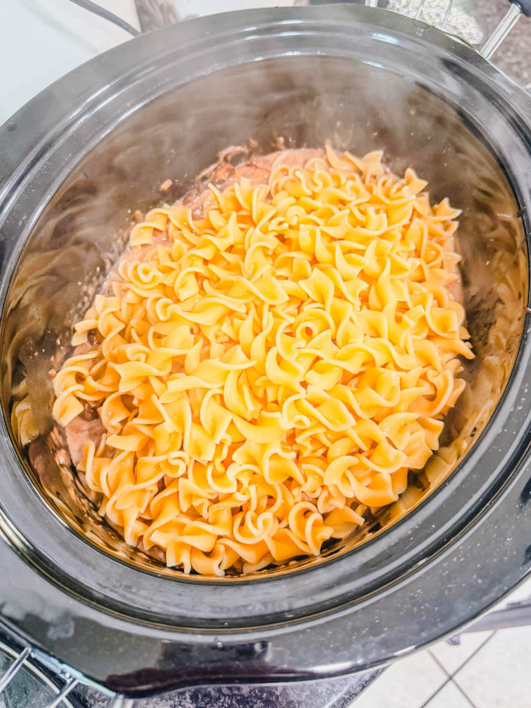 cooked egg noodles added to the crock pot of beef.