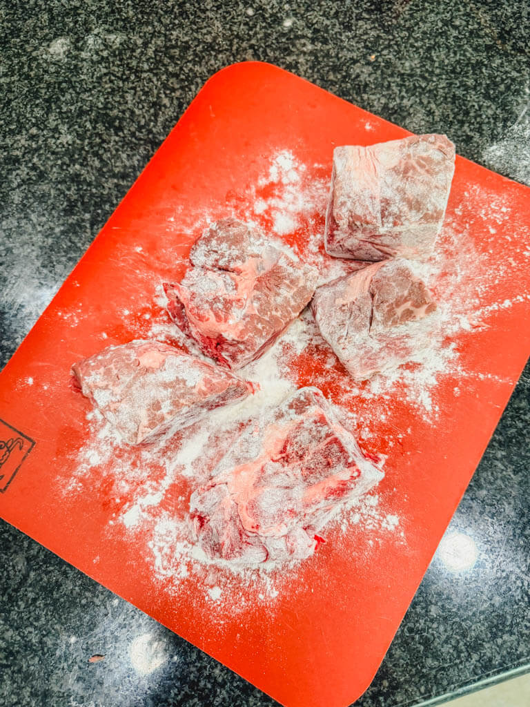 Large chunks of beef roast dusted with flour.