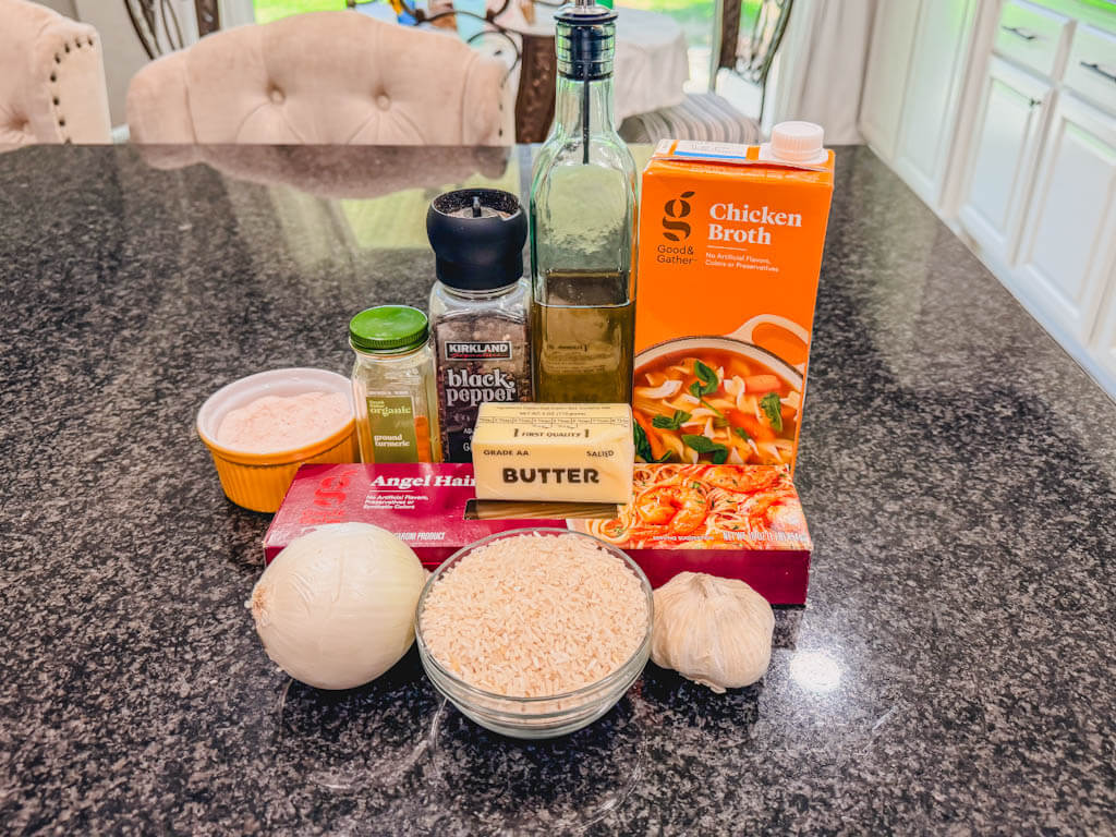 Ingredients for homemade rice pilaf including rice, angel hair pasta, butter, olive oil, onion, garlic, chicken broth, turmeric, salt, and pepper.