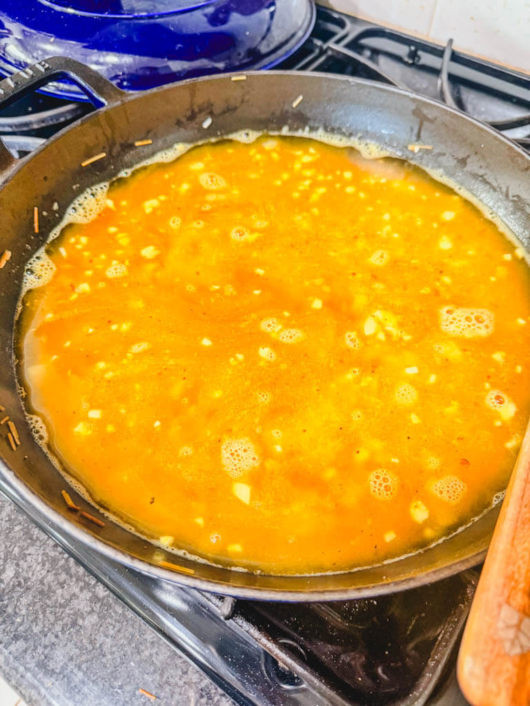 Chicken broth added to the skillet.