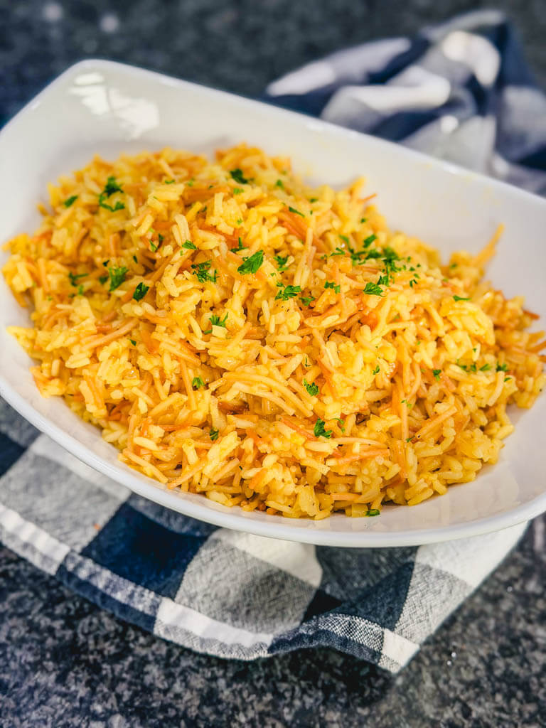 Bowl of homemade rice pilaf garnished with parsley.