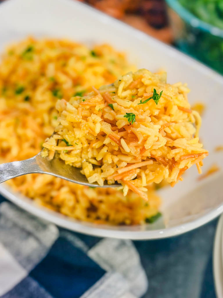 Close up of a spoonful of fluffy homemade rice pilaf showing toasted vermicelli and tender rice.