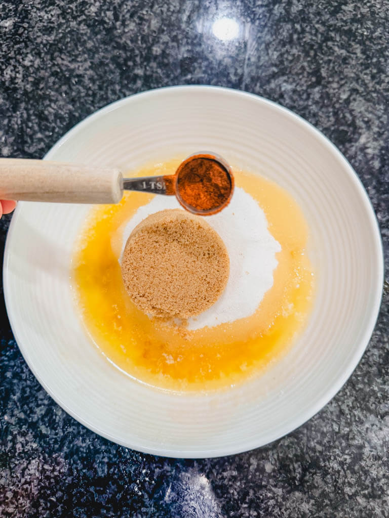 Ground cinnamon being added to the streusel topping.