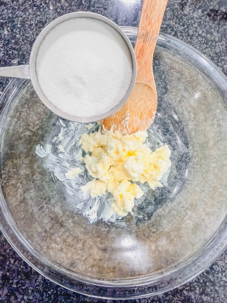 Butter and granulated sugar being creamed together in a large mixing bowl.