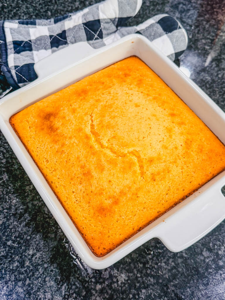 Freshly baked homemade sweet cornbread in a white 8x8 baking dish.