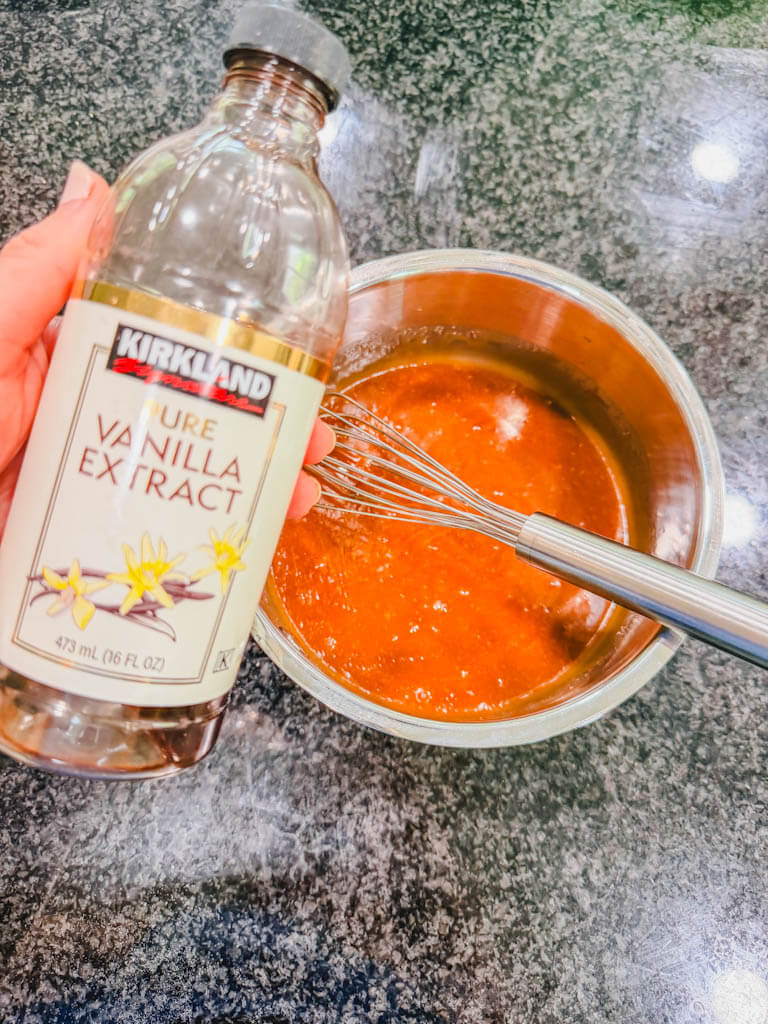 Vanilla extract being added to homemade brown sugar Biscoff icing.