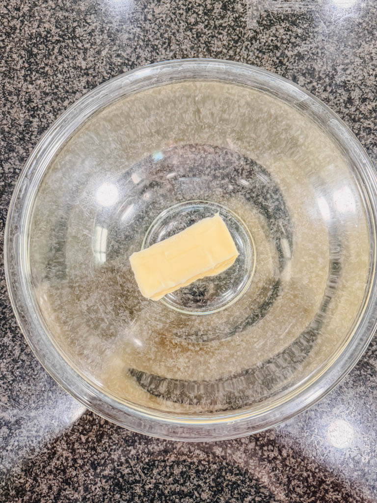 Softened butter in a large glass mixing bowl for Biscoff banana bread.