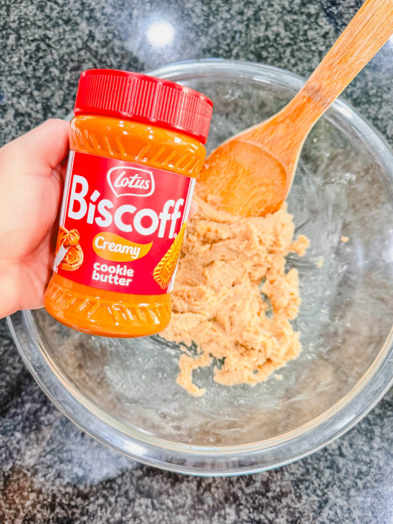 Jar of creamy Biscoff cookie butter being added to the butter and brown sugar mixture.