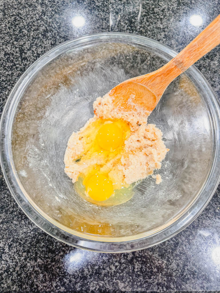 Two eggs added to creamed butter and sugar for homemade banana muffins.
